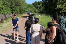 Auf einem Weg entlang der Panzersperren der Höckerlinie eine Gruppe Jugendlicher.