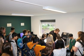 Ein Mitarbeiter des Bürgerlabors zeigt der Schulklasse, wie der 3d-Drucker des Bürgerlabors funktioniert.